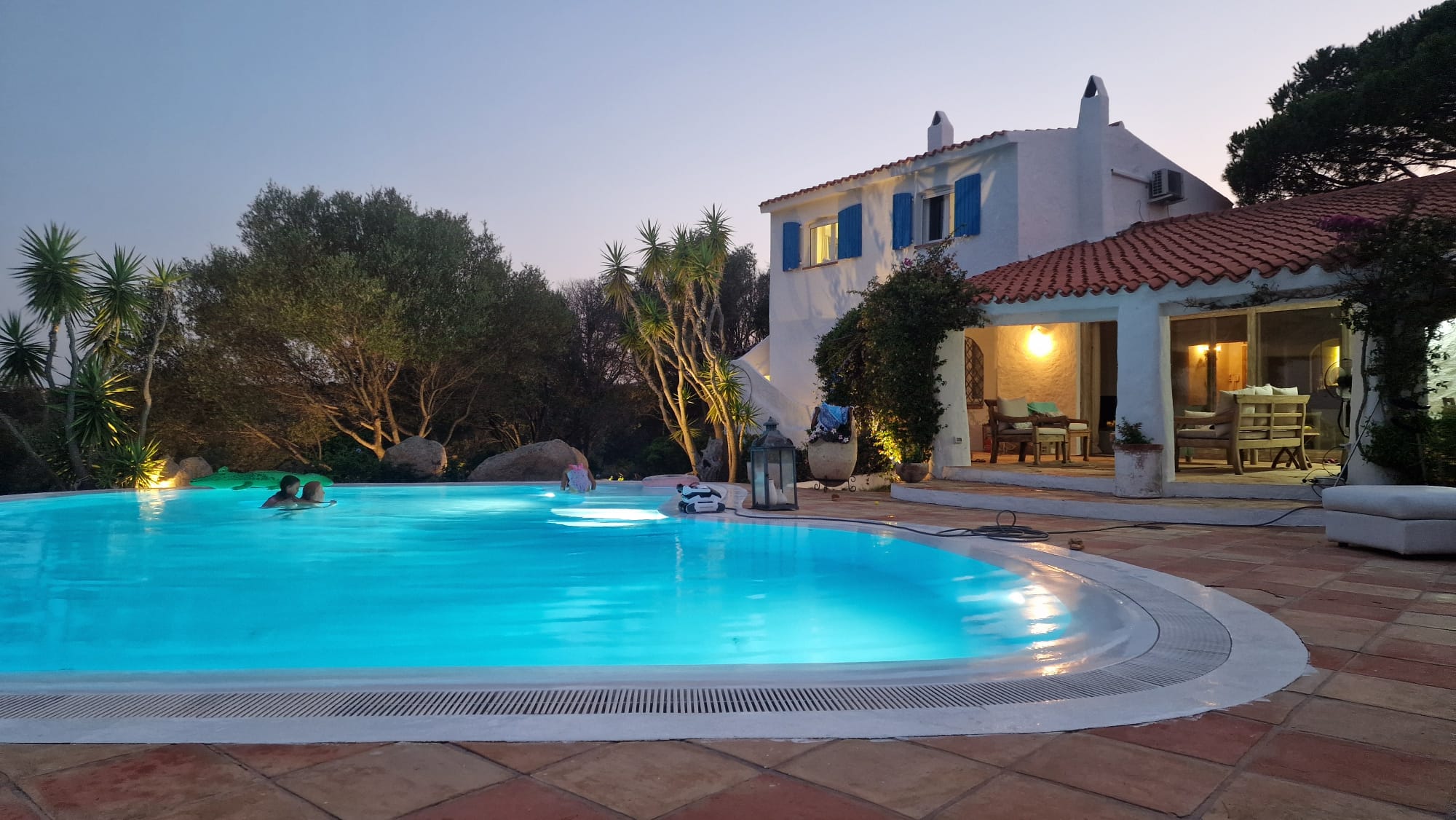 Illuminated pool and villa at sunset
