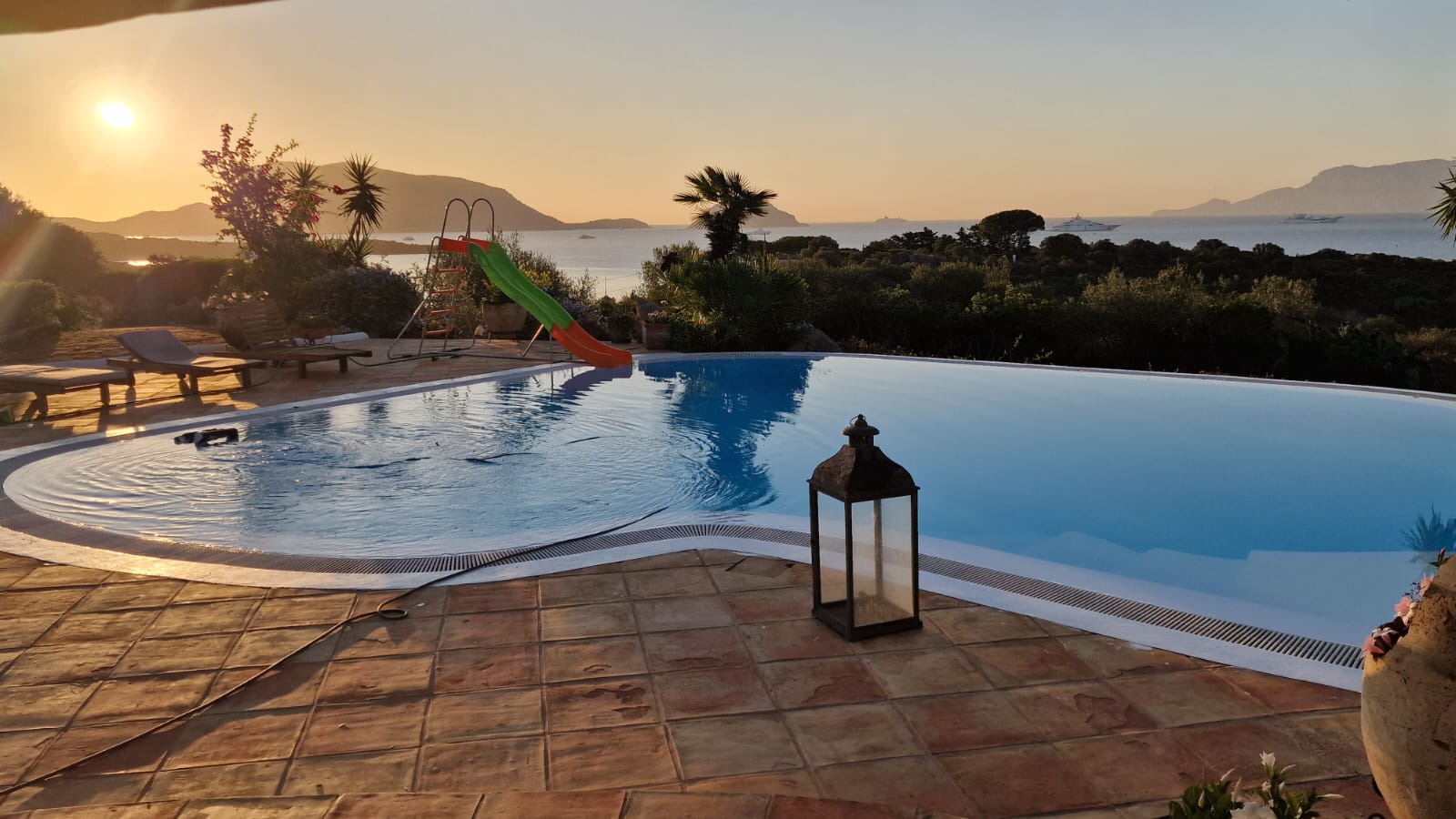 Sunset view pool slide sunbeds sea