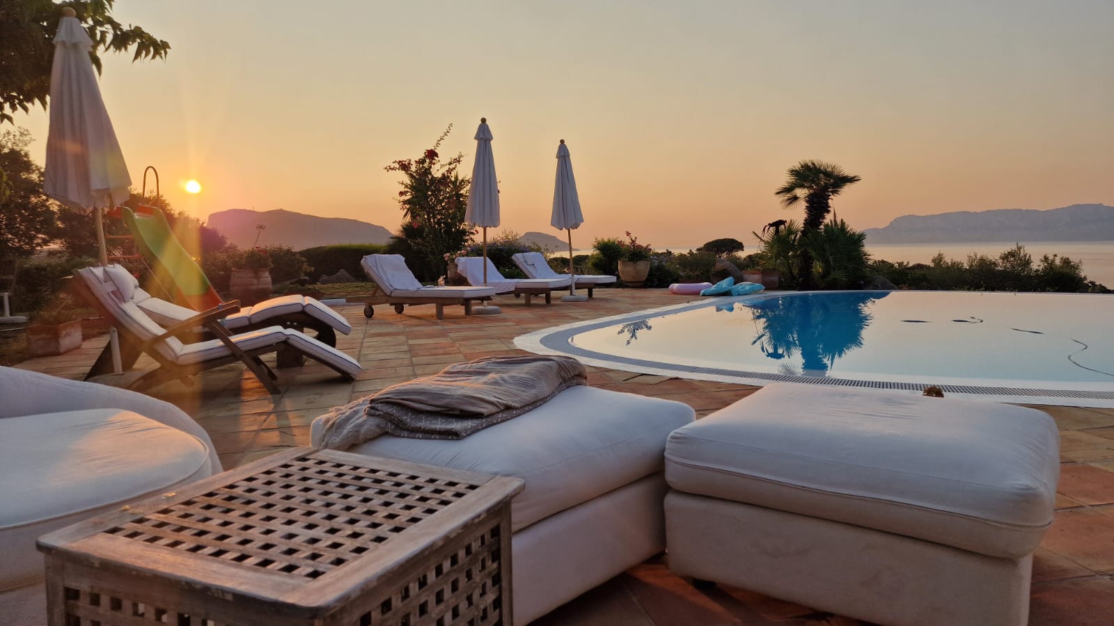 Swimming pool area and sea views at sunset